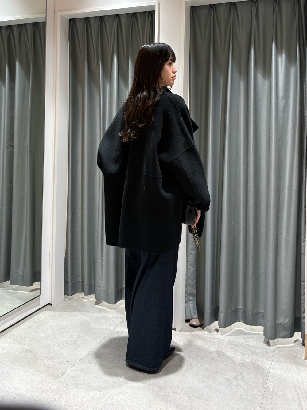 ブラック系のその他アウター、ホワイト系のニット/セーター、ブラック系のベルトを着用したレディースの秋コーディネートの3枚目の写真