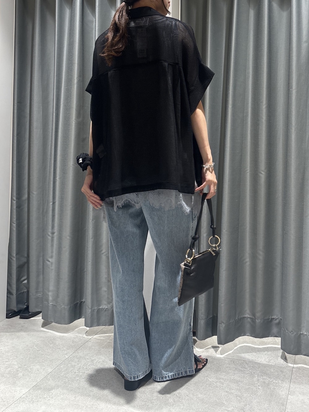 ブラック系のテーラードジャケット、グレー系のTシャツ/カットソー、ブルー系のデニムパンツを着用したレディースの春コーディネートの3枚目の写真