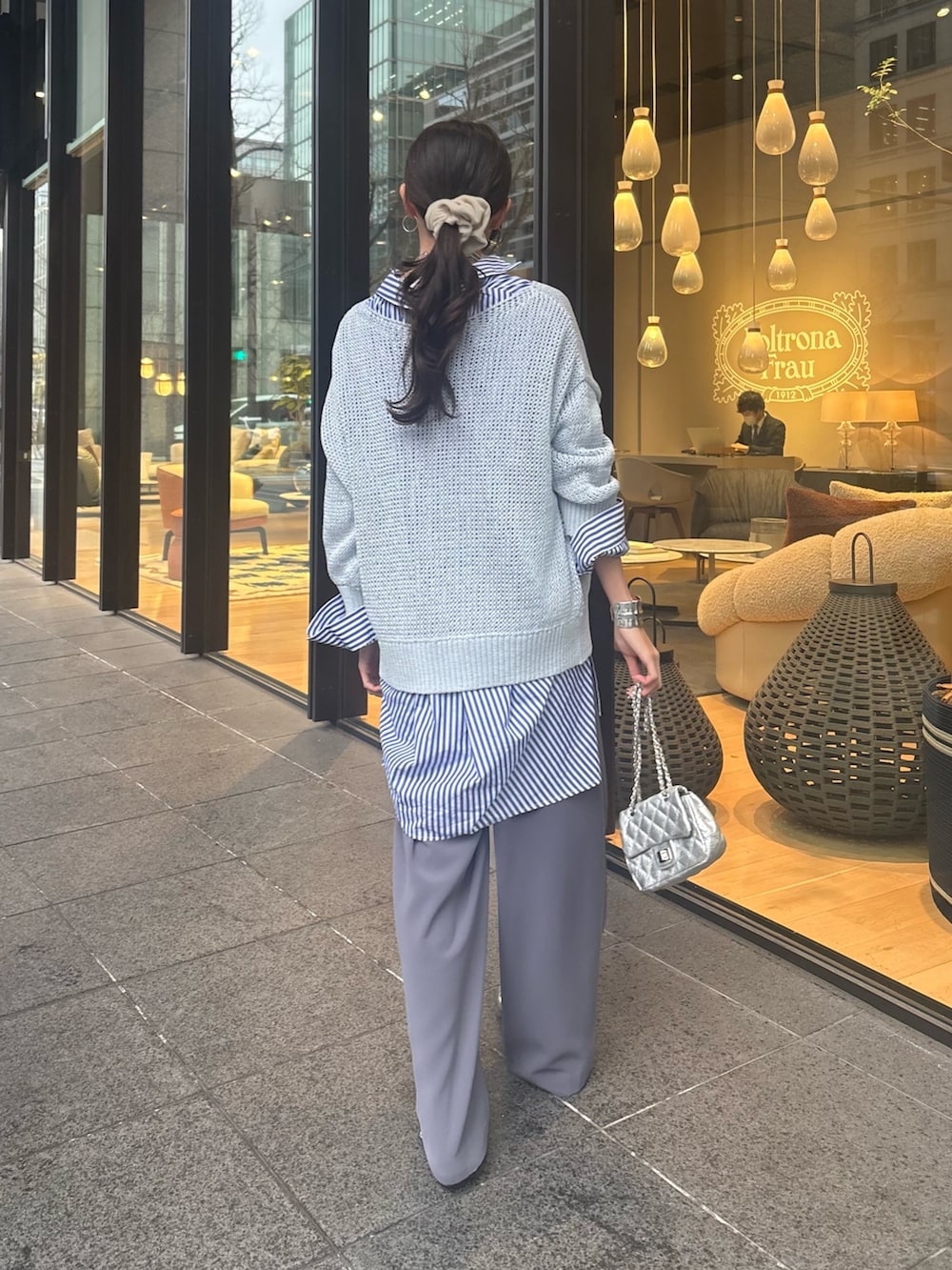 ブルー系のニット/セーター、ブルー系のシャツ/ブラウス、グレー系のスラックスを着用したレディースの冬コーディネートの2枚目の写真