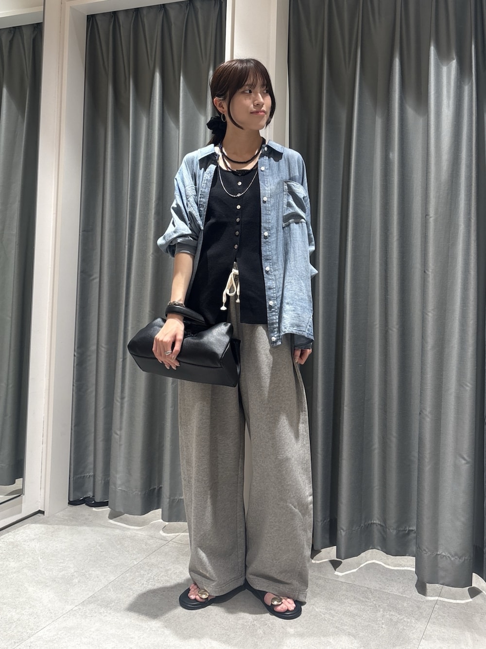 ブルー系のシャツ/ブラウス、ブラック系のニット/セーター、グレー系のその他パンツを着用したレディースの春コーディネートの4枚目の写真