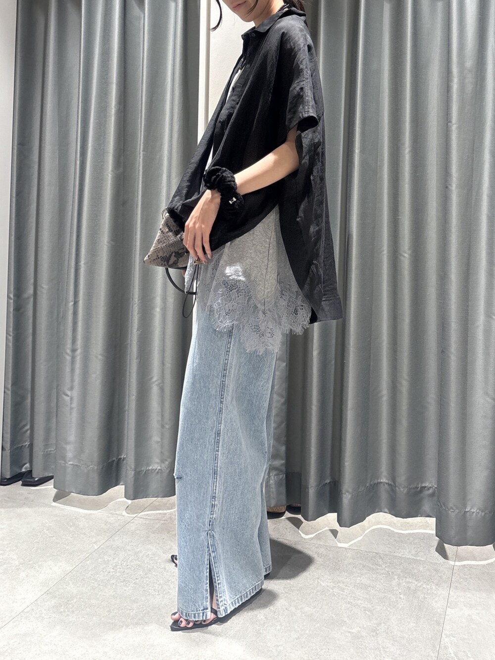 ブラック系のシャツ/ブラウス、グレー系のTシャツ/カットソー、ブルー系のデニムパンツを着用したレディースの春コーディネートの2枚目の写真
