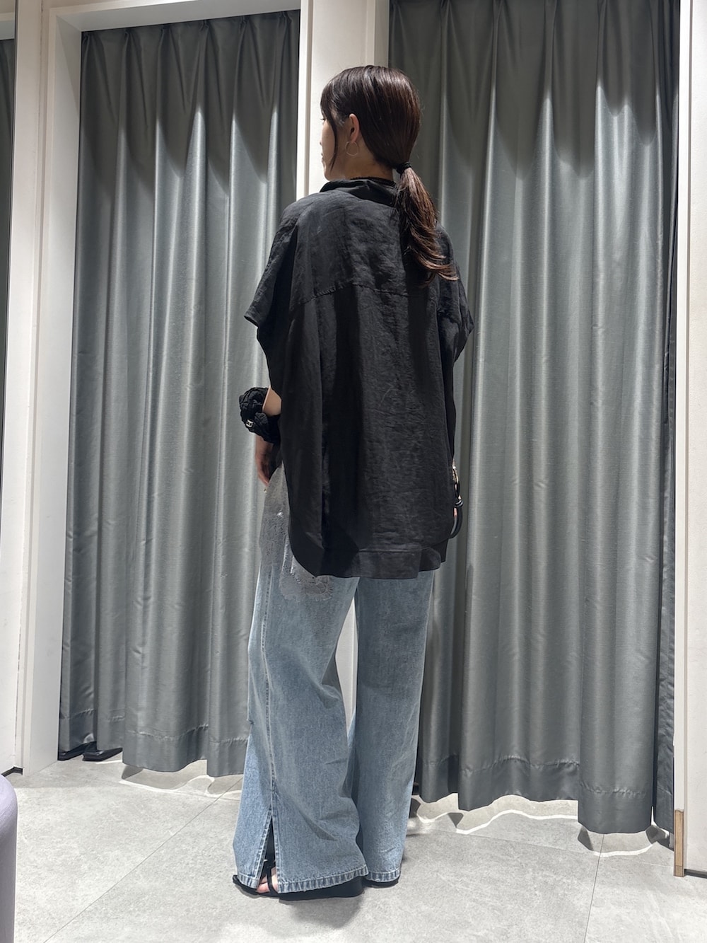 ブラック系のシャツ/ブラウス、グレー系のTシャツ/カットソー、ブルー系のデニムパンツを着用したレディースの春コーディネートの3枚目の写真