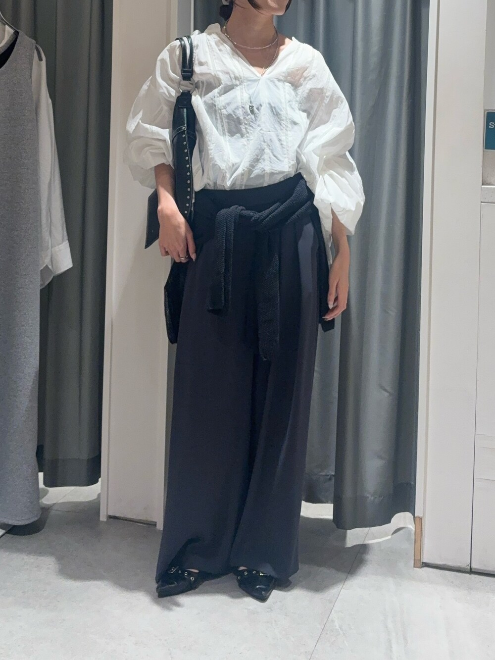 ホワイト系のシャツ/ブラウス、ブラック系のニット/セーター、グレー系のスラックスを着用したレディースの春コーディネートの3枚目の写真