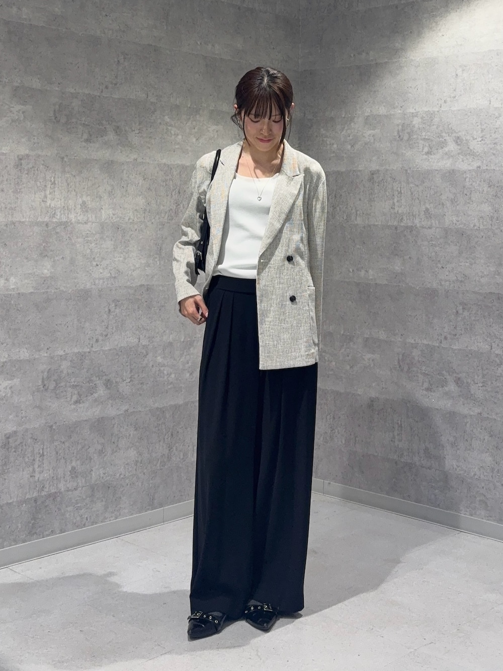 ホワイト系のテーラードジャケット、ホワイト系のニット/セーター、ブラック系のスラックスを着用したレディースの春コーディネートの4枚目の写真
