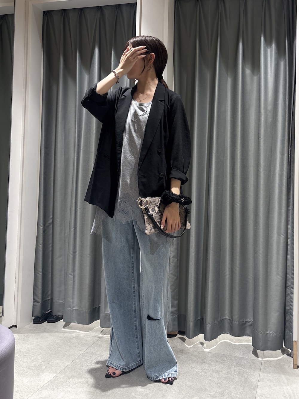 ブラック系のテーラードジャケット、グレー系のTシャツ/カットソー、ブルー系のデニムパンツを着用したレディースの春コーディネートの5枚目の写真