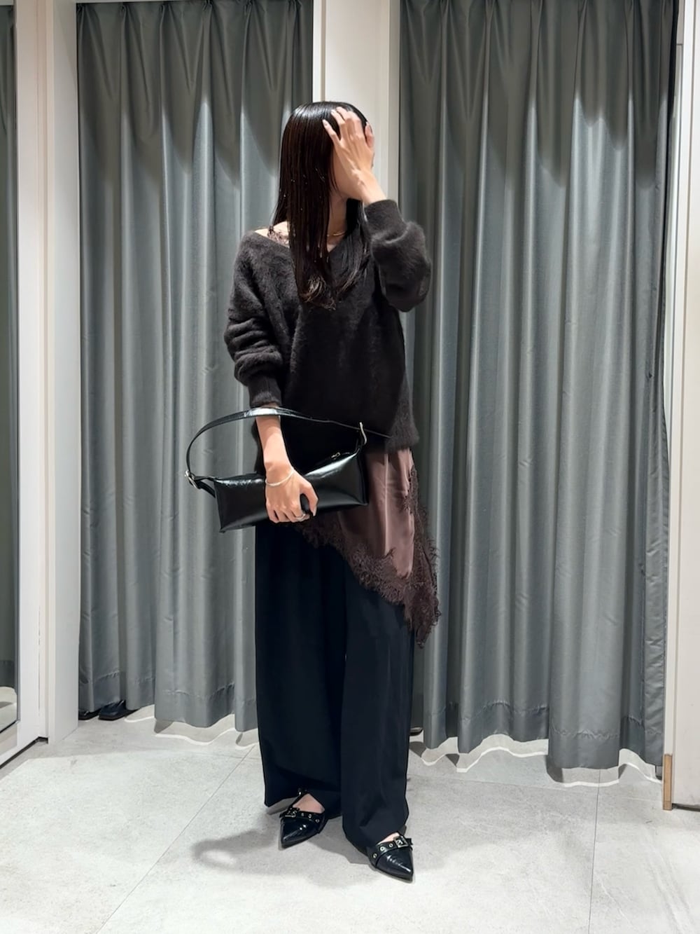 ブラウン系のニット/セーター、ブラウン系のキャミソール、ブラック系のスラックスを着用したレディースの秋コーディネートの3枚目の写真