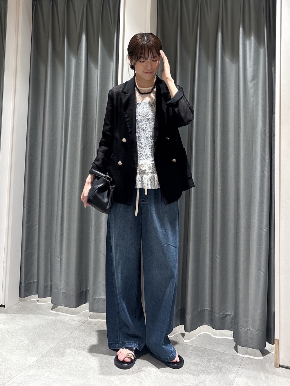 ブラック系のテーラードジャケット、ホワイト系のTシャツ/カットソー、ブルー系のデニムパンツを着用したレディースの春コーディネートの4枚目の写真