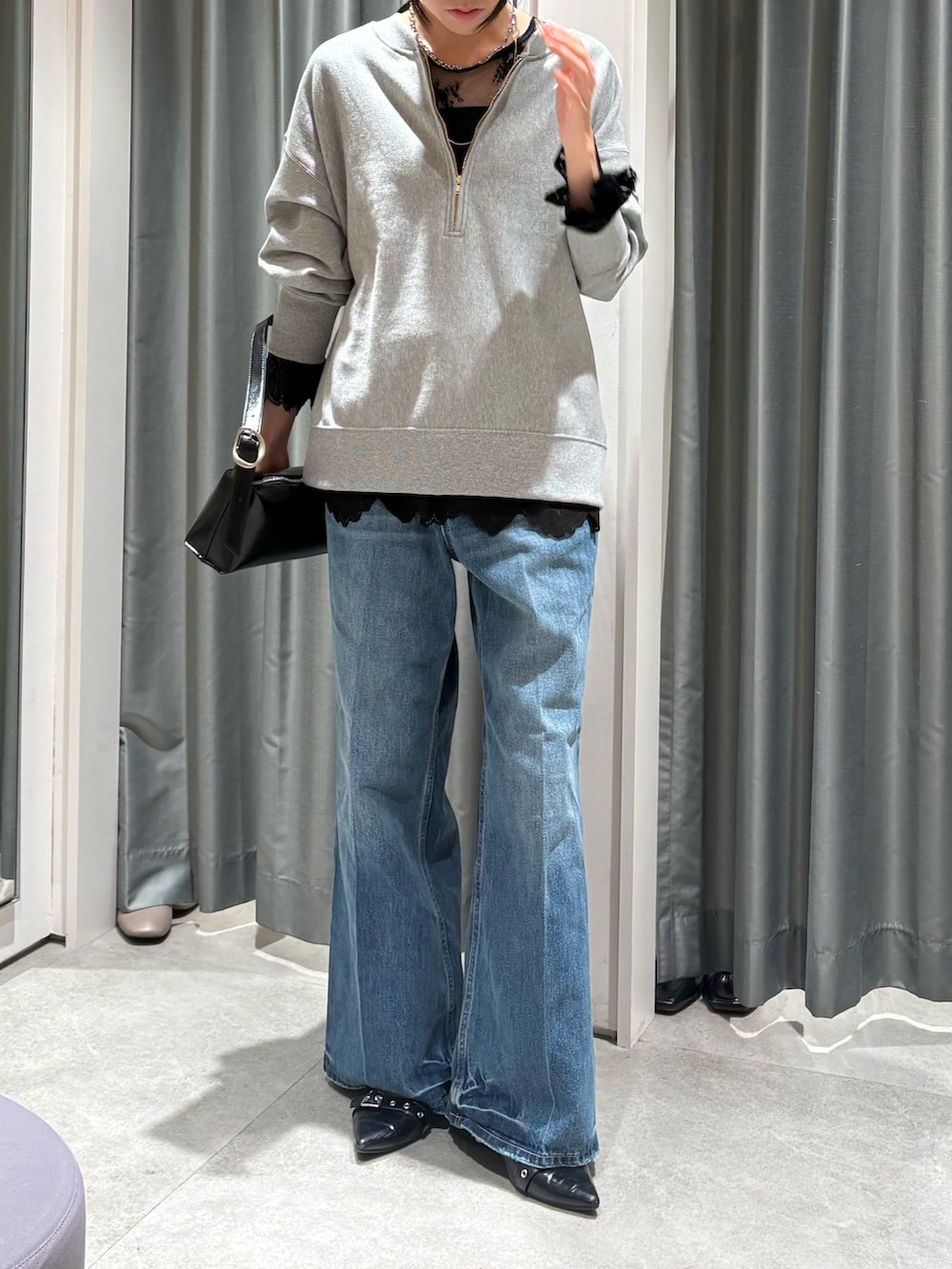 グレー系のスウェット、ブラック系のシャツ/ブラウス、ブルー系のデニムパンツを着用したレディースの冬コーディネートの2枚目の写真