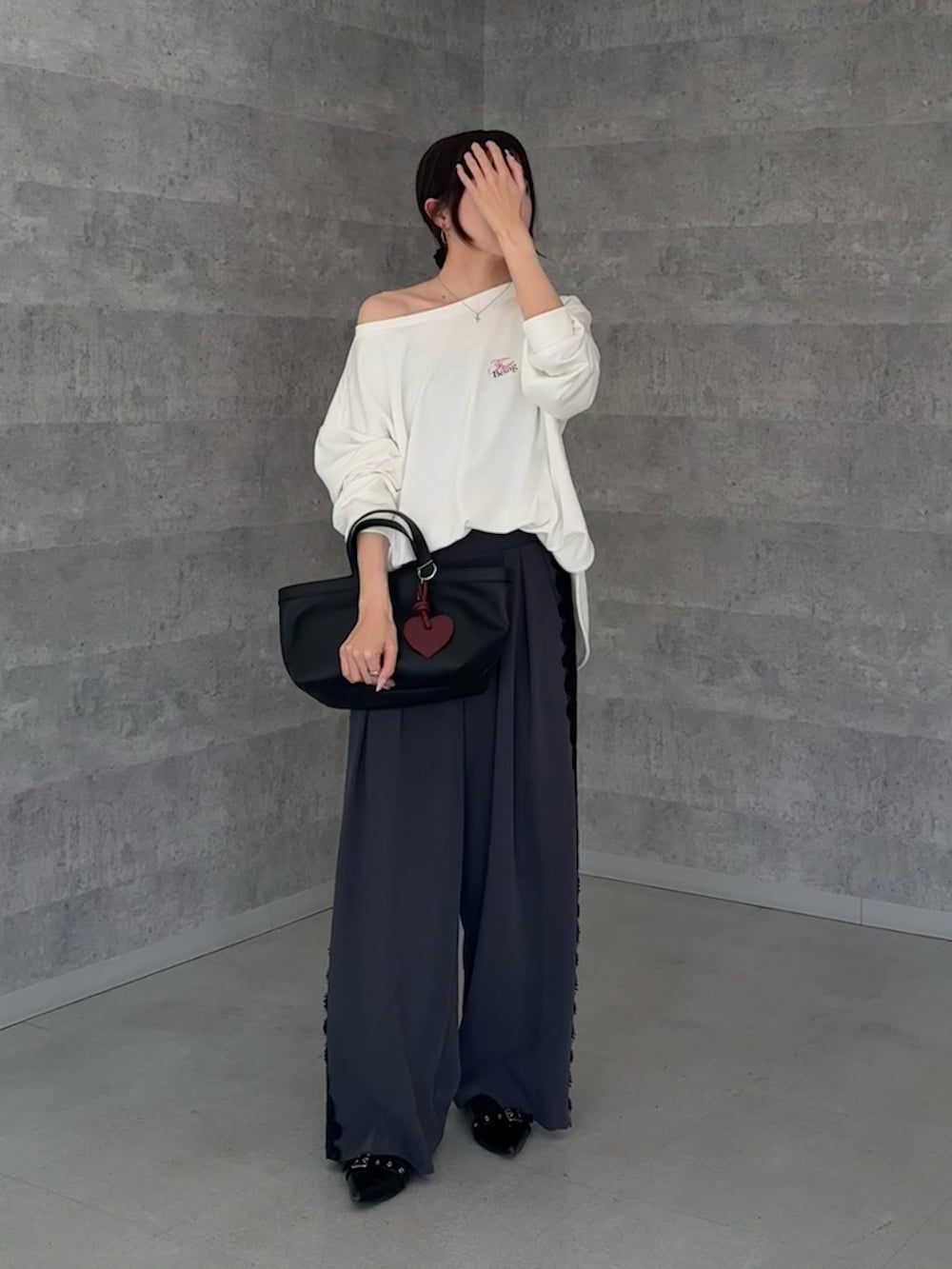 ホワイト系のTシャツ/カットソー、グレー系のその他パンツ、ブラック系のショルダーバッグを着用したレディースの冬コーディネートの2枚目の写真