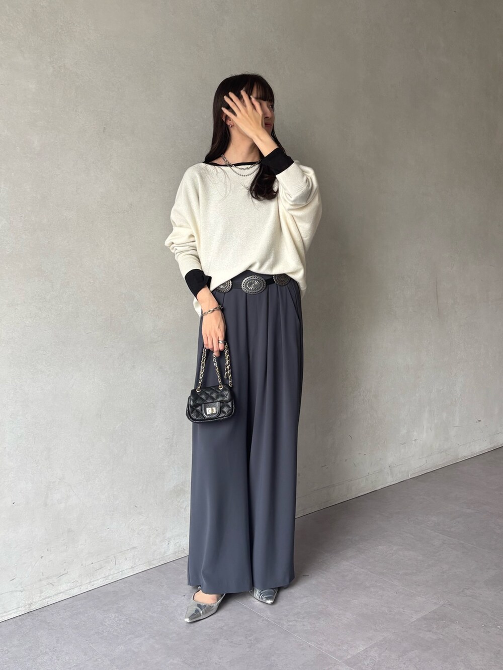 ホワイト系のニット/セーター、グレー系のスラックス、ブラック系のTシャツ/カットソーを着用したレディースの冬コーディネートの3枚目の写真