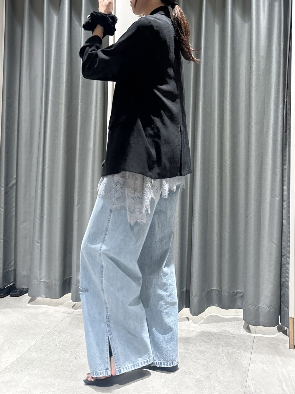 ブラック系のテーラードジャケット、グレー系のTシャツ/カットソー、ブルー系のデニムパンツを着用したレディースの春コーディネートの2枚目の写真