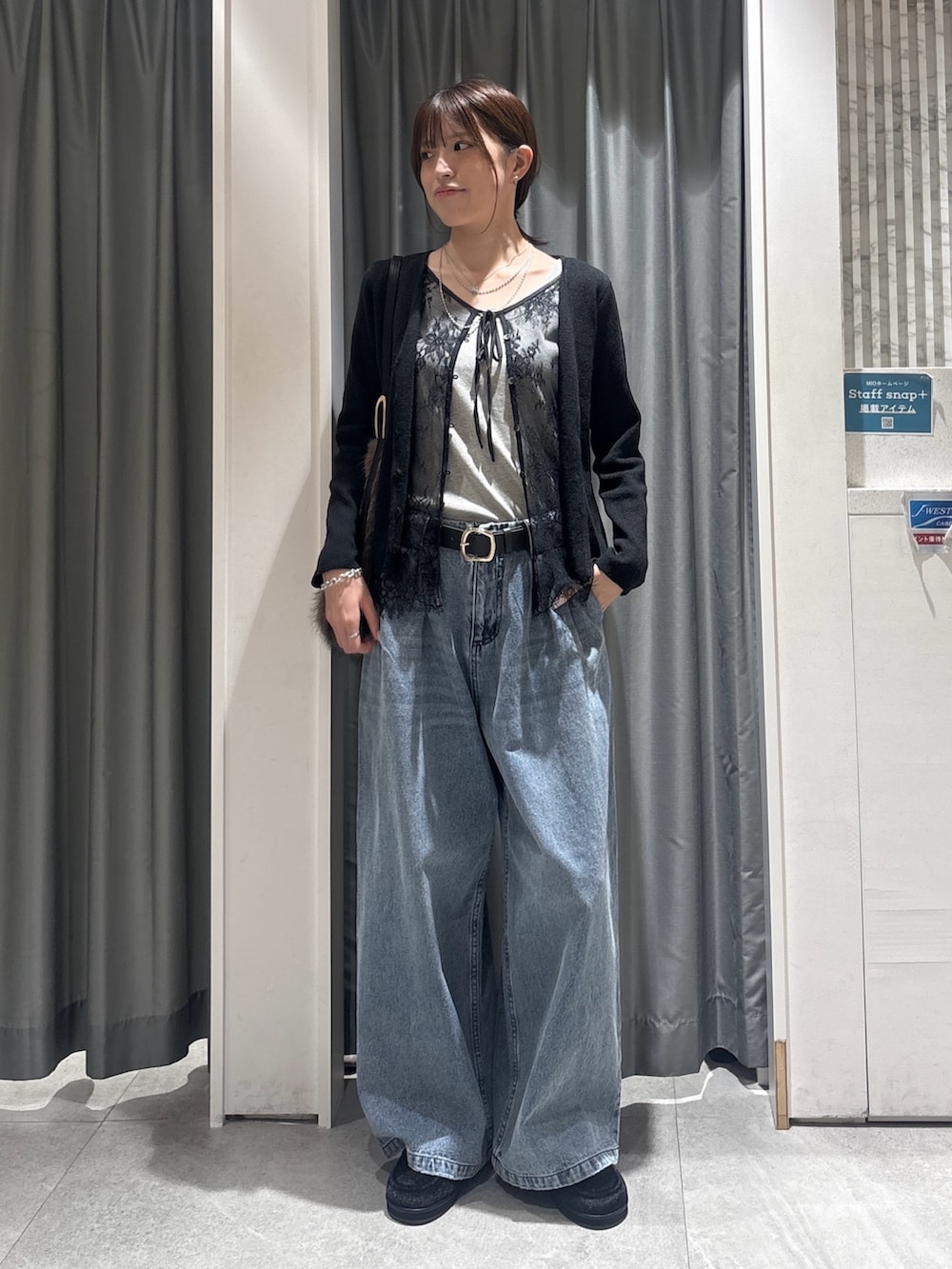 グレー系のカーディガン/ボレロ、グレー系のニット/セーター、ブルー系のデニムパンツを着用したレディースの秋コーディネートの3枚目の写真