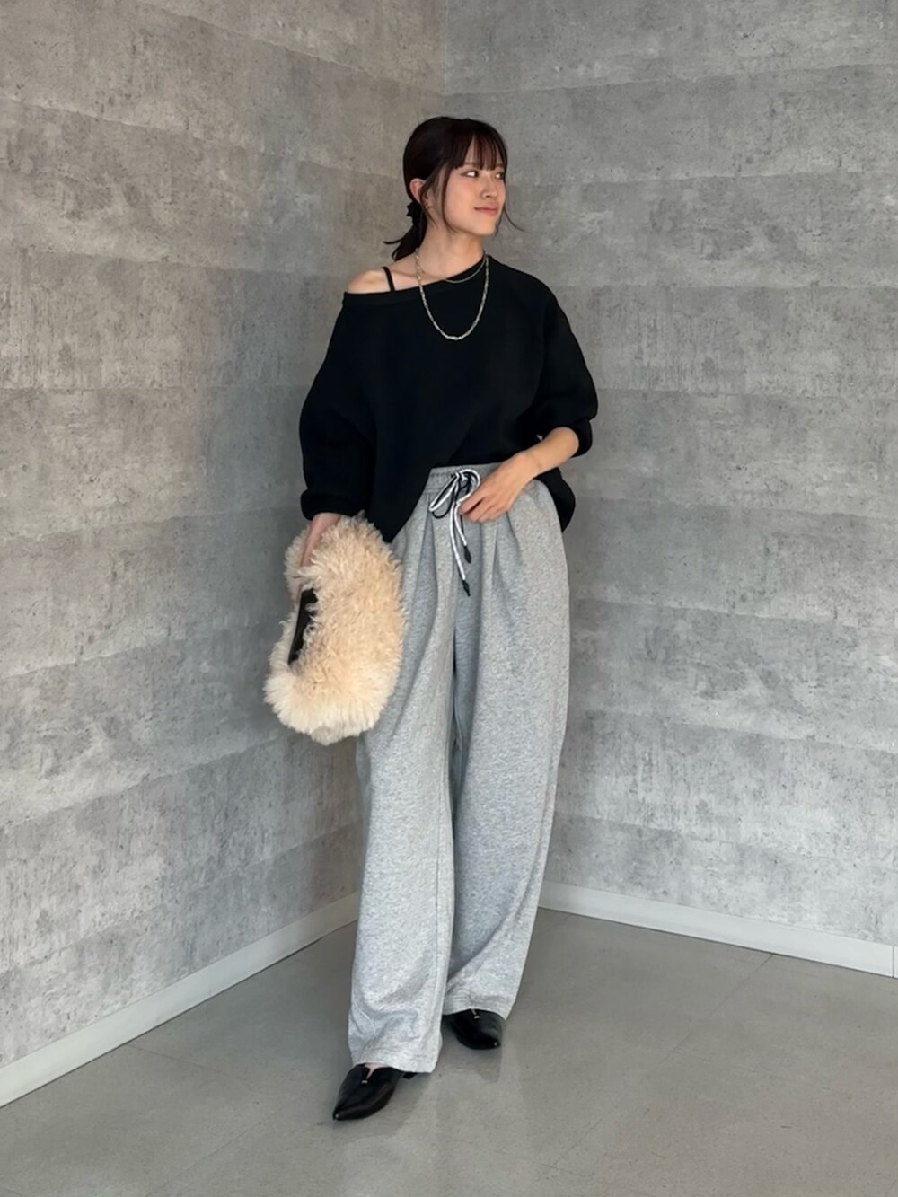 ブラック系のニット/セーター、ホワイト系のショルダーバッグ、ブラック系のパンプスを着用したレディースの秋コーディネートの2枚目の写真