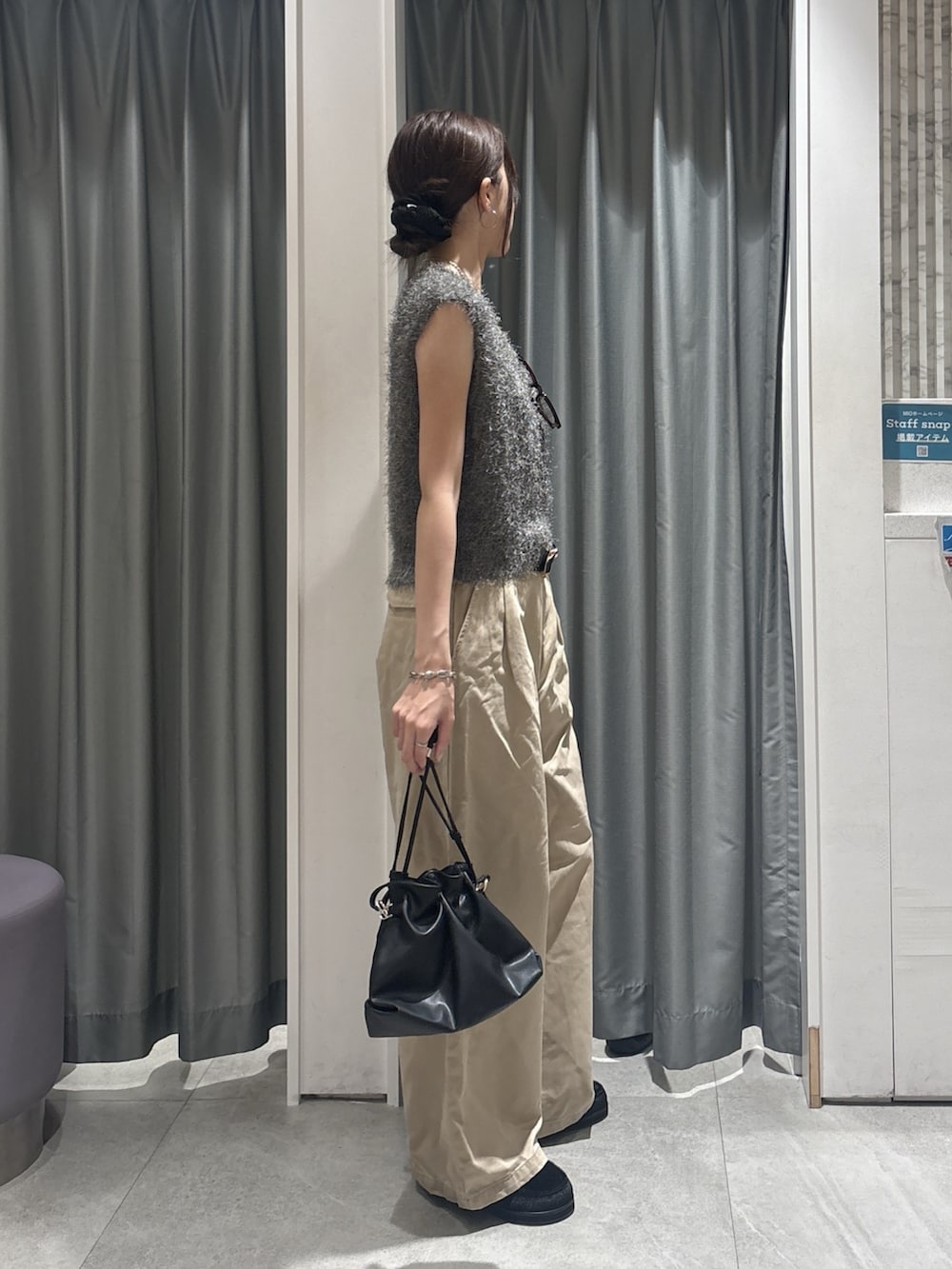 グレー系のニット/セーター、ベージュ系のチノパンツ、ブラック系のトートバッグを着用したレディースの秋コーディネートの3枚目の写真