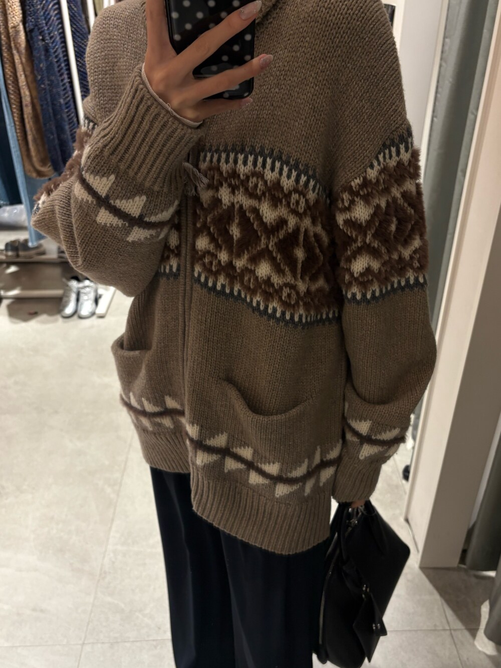 ホワイト系のTシャツ/カットソー、ベージュ系のニット/セーター、ブルー系のスラックスを着用したレディースの冬コーディネートの3枚目の写真