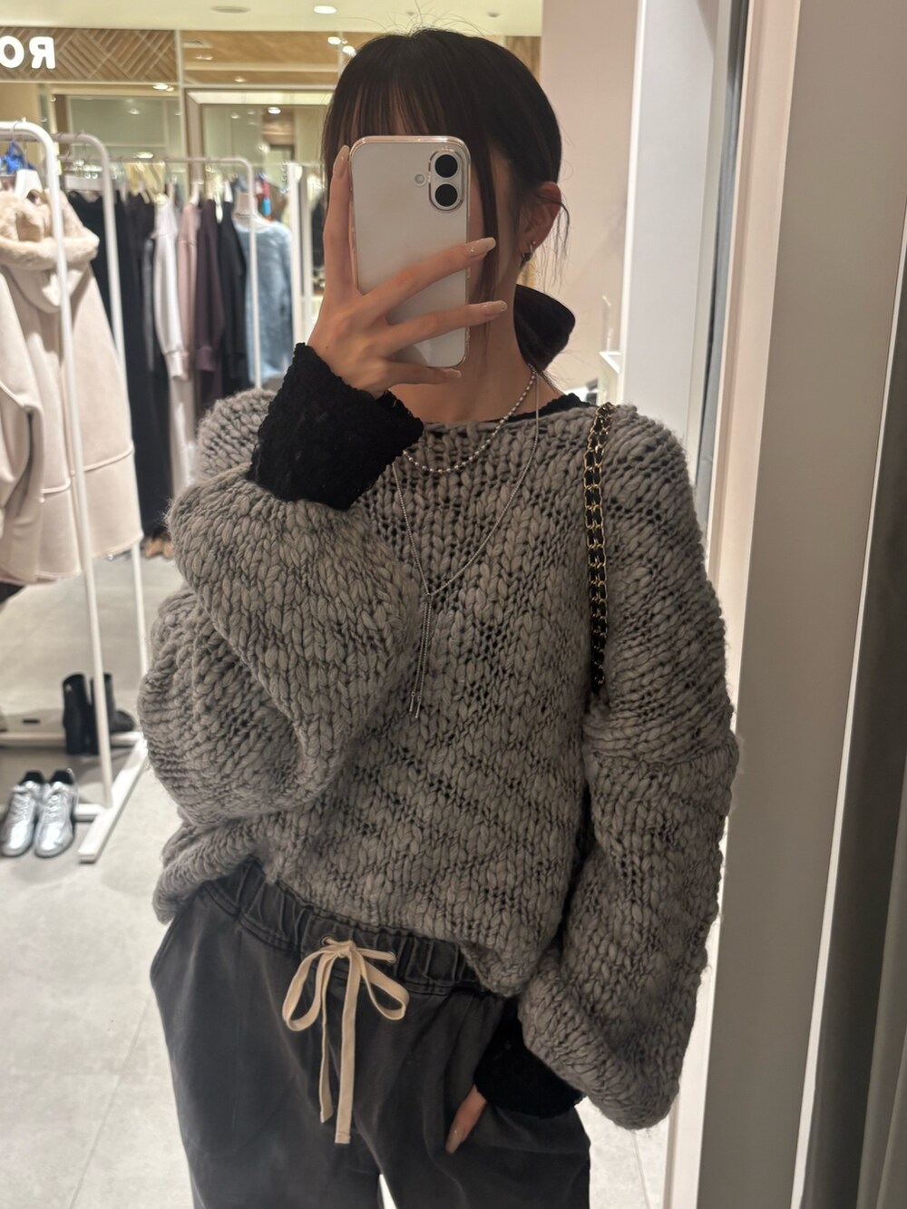 グレー系のニット/セーター、ブラック系のTシャツ/カットソー、ブラック系のデニムパンツを着用したレディースの秋コーディネートの3枚目の写真