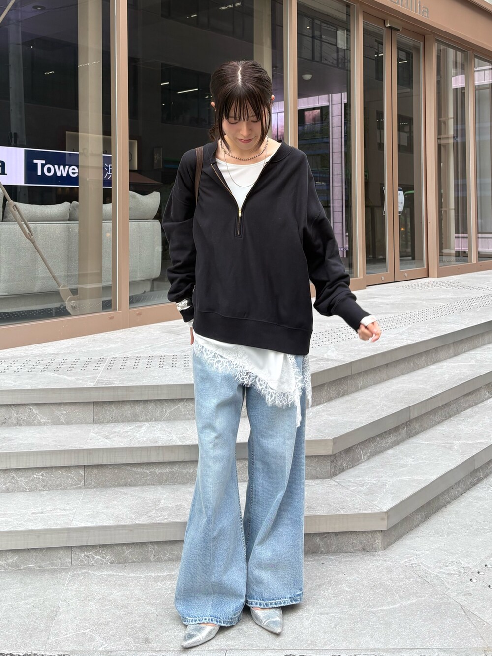 ブラック系のスウェット、ホワイト系のシャツ/ブラウス、ブルー系のデニムパンツを着用したレディースの冬コーディネートの3枚目の写真