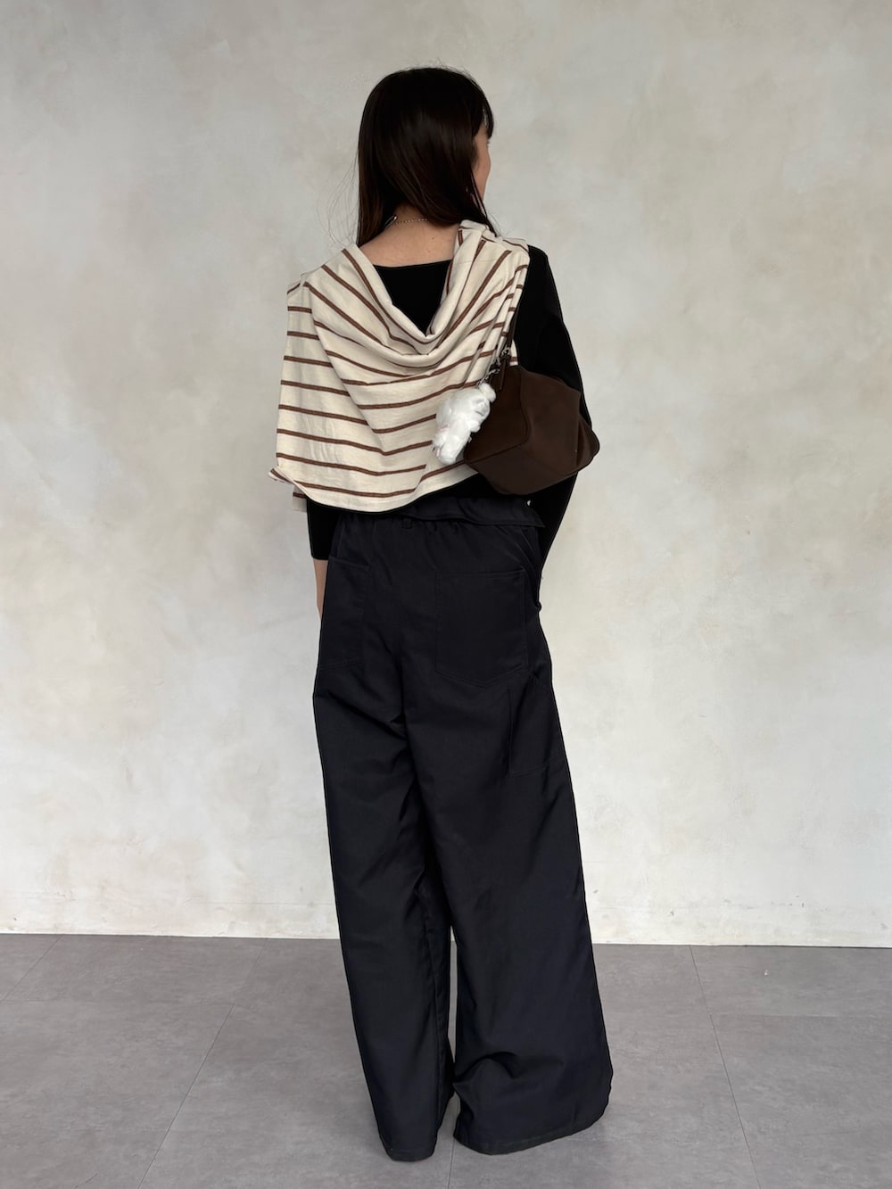 ブラック系のニット/セーター、グレー系のその他パンツを着用したレディースの冬コーディネートの3枚目の写真