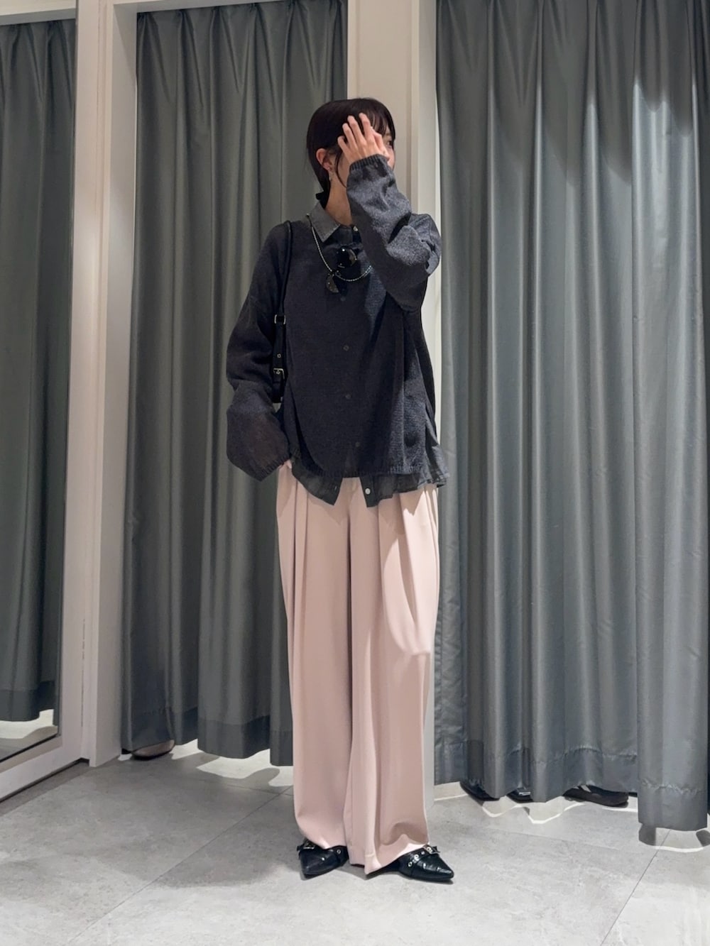 ブラック系のシャツ/ブラウス、グレー系のニット/セーター、ピンク系のスラックスを着用したレディースの春コーディネートの3枚目の写真