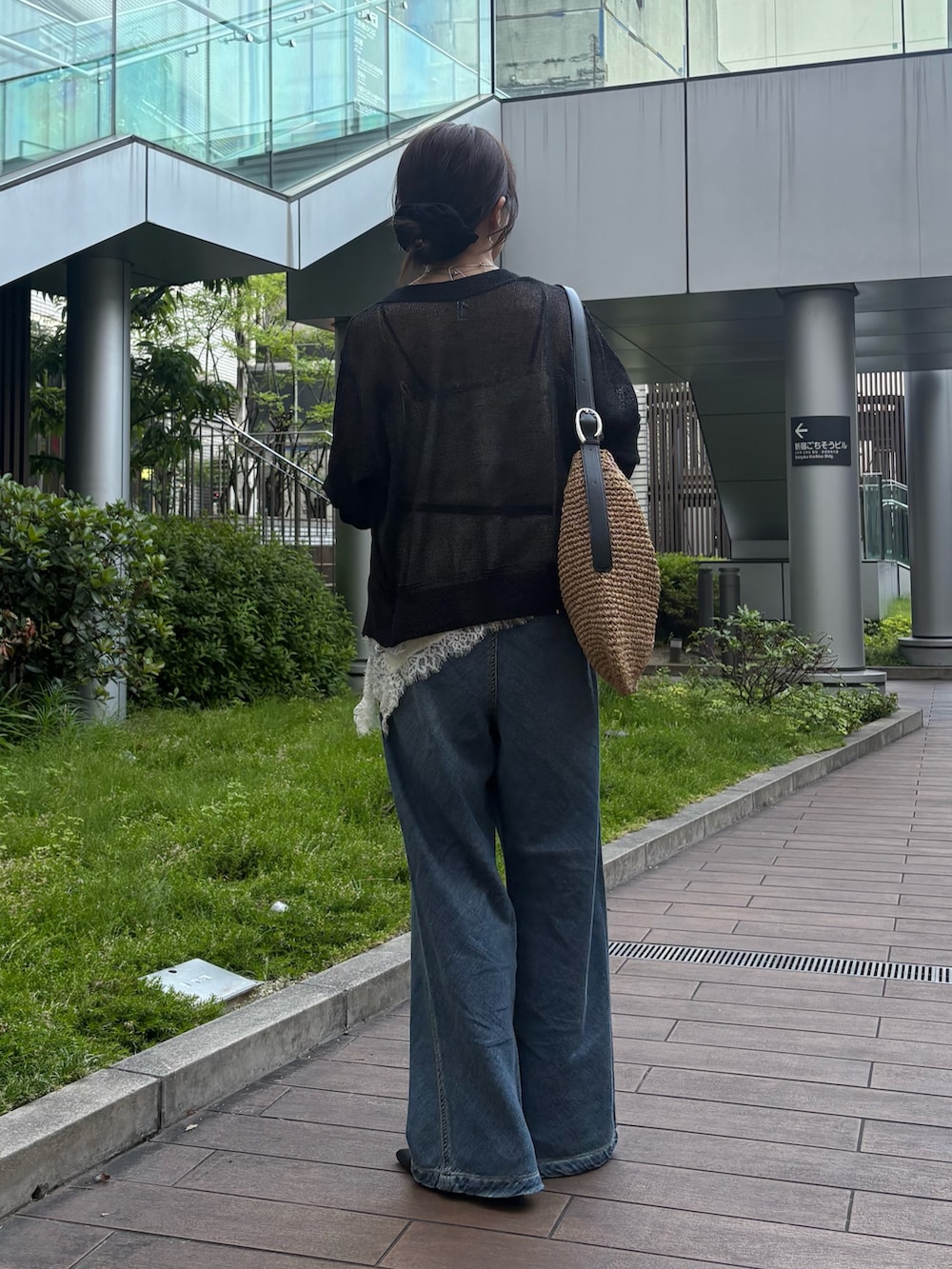 ブラック系のカーディガン/ボレロ、ホワイト系のシャツ/ブラウス、ブルー系のデニムパンツを着用したレディースの春コーディネートの2枚目の写真
