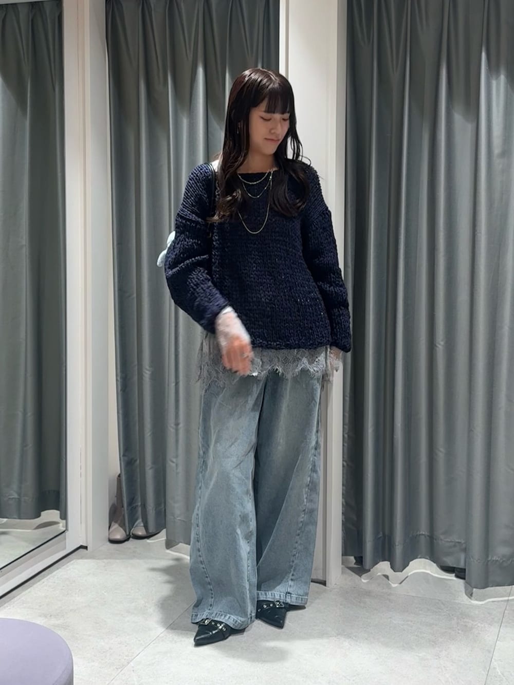 ブルー系のニット/セーター、グレー系のTシャツ/カットソー、ブルー系のデニムパンツを着用したレディースの冬コーディネートの2枚目の写真