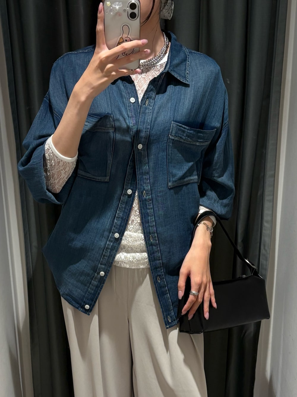 ブラック系のショルダーバッグ、ブルー系のシャツ/ブラウス、グレー系のスラックスを着用したレディースの夏コーディネートの3枚目の写真