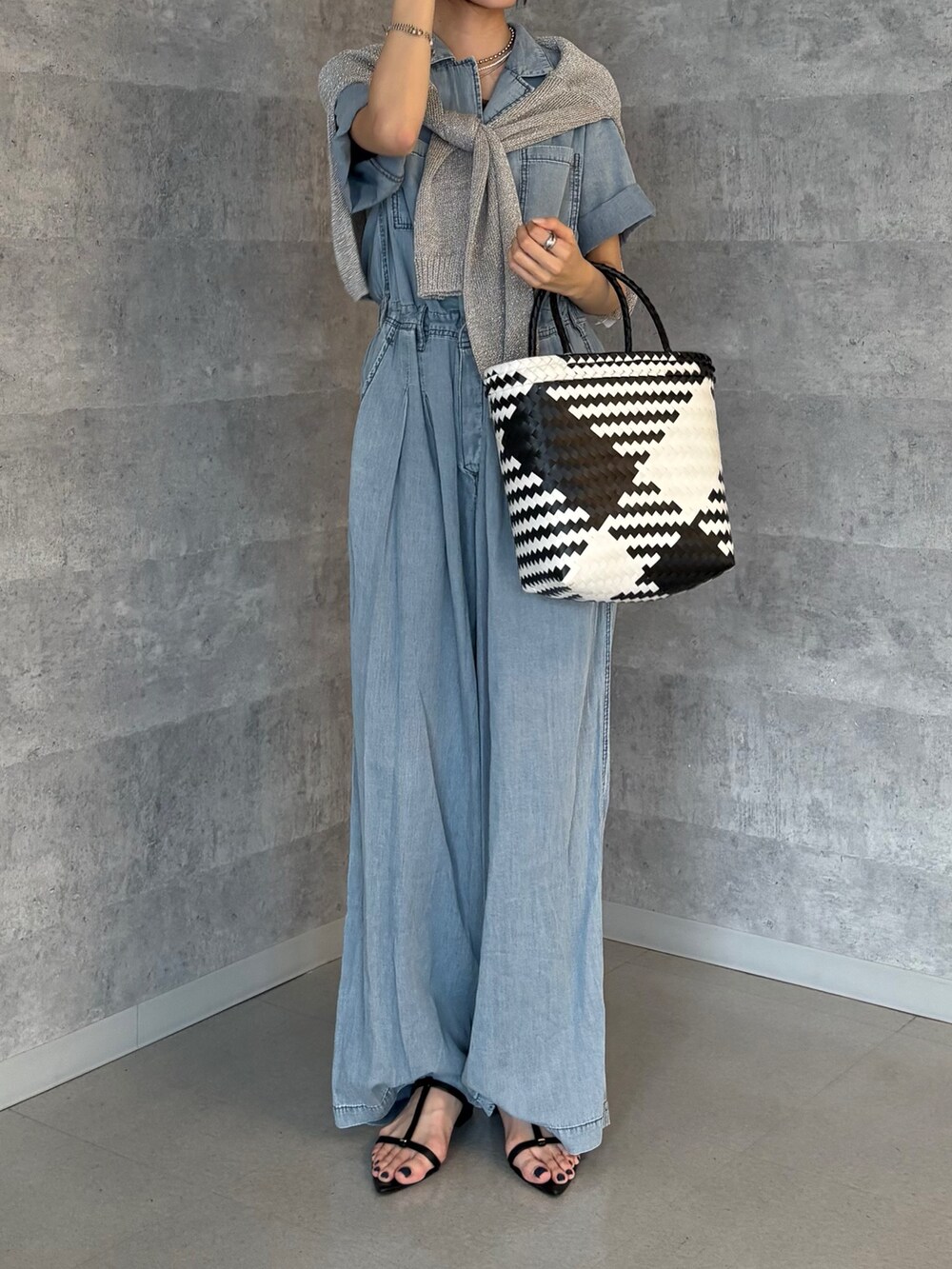 ブルー系のつなぎ/オールインワン、シルバー系のニット/セーター、ブラック系のサンダルを着用したレディースの夏コーディネートの2枚目の写真