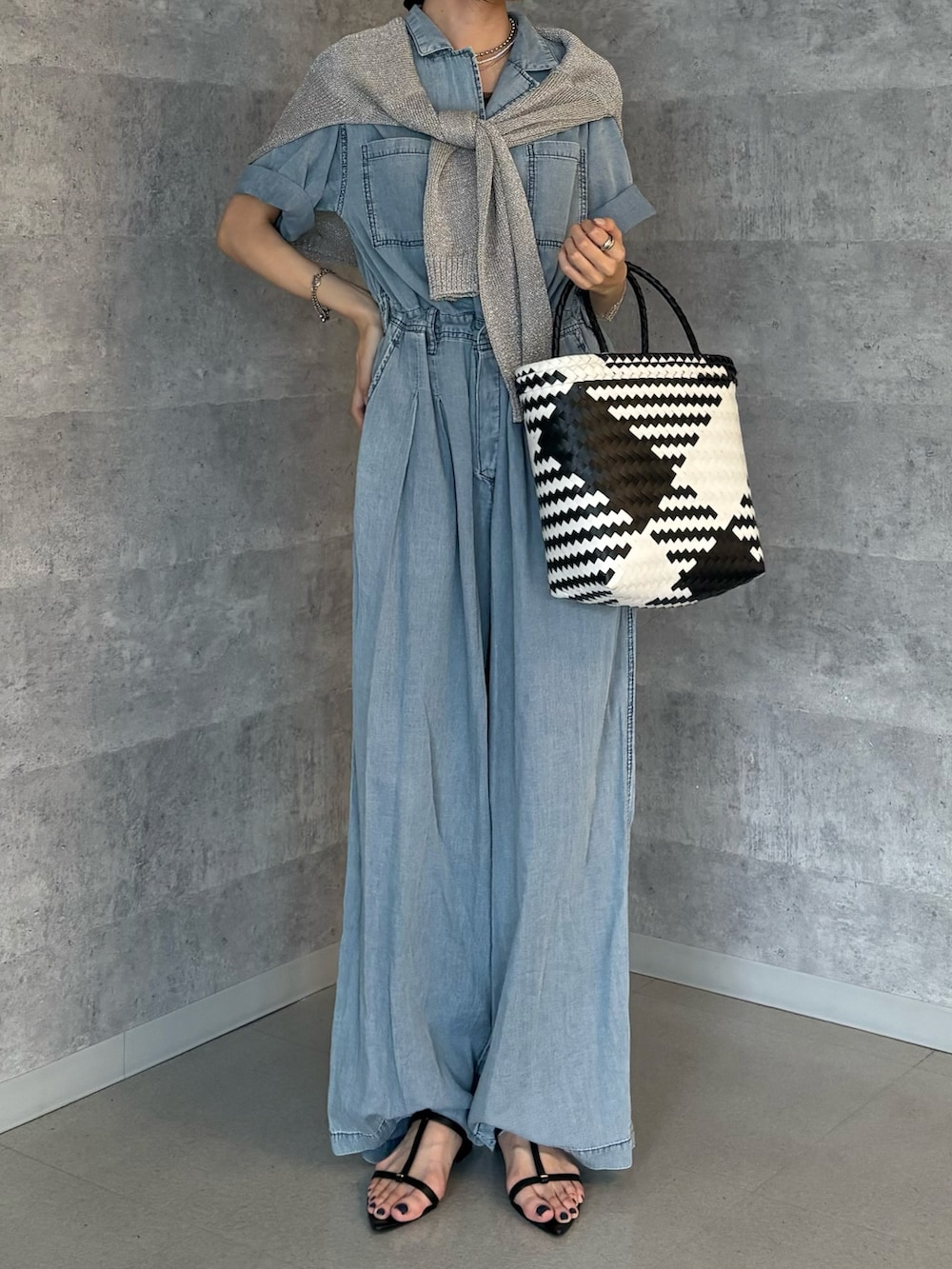 ブルー系のつなぎ/オールインワン、シルバー系のニット/セーター、ブラック系のサンダルを着用したレディースの夏コーディネートの3枚目の写真