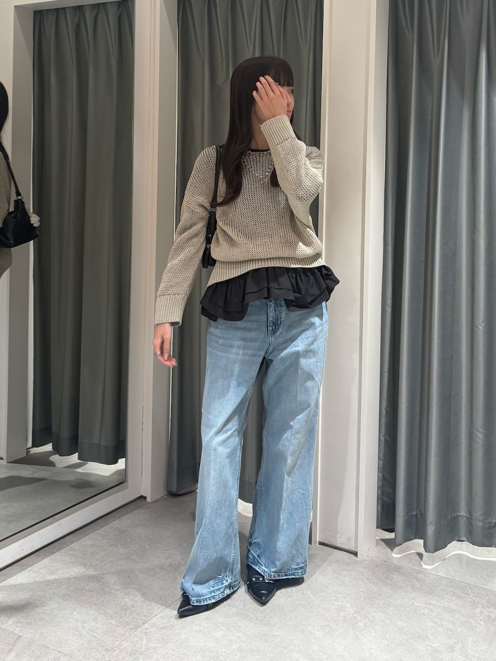 ベージュ系のニット/セーター、ブラック系のTシャツ/カットソー、ブルー系のデニムパンツを着用したレディースの冬コーディネートの2枚目の写真