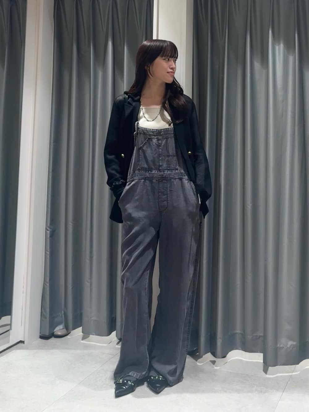 ベージュ系のニット/セーター、ブラック系のつなぎ/オールインワン、ブラック系のテーラードジャケットを着用したレディースの春コーディネートの2枚目の写真