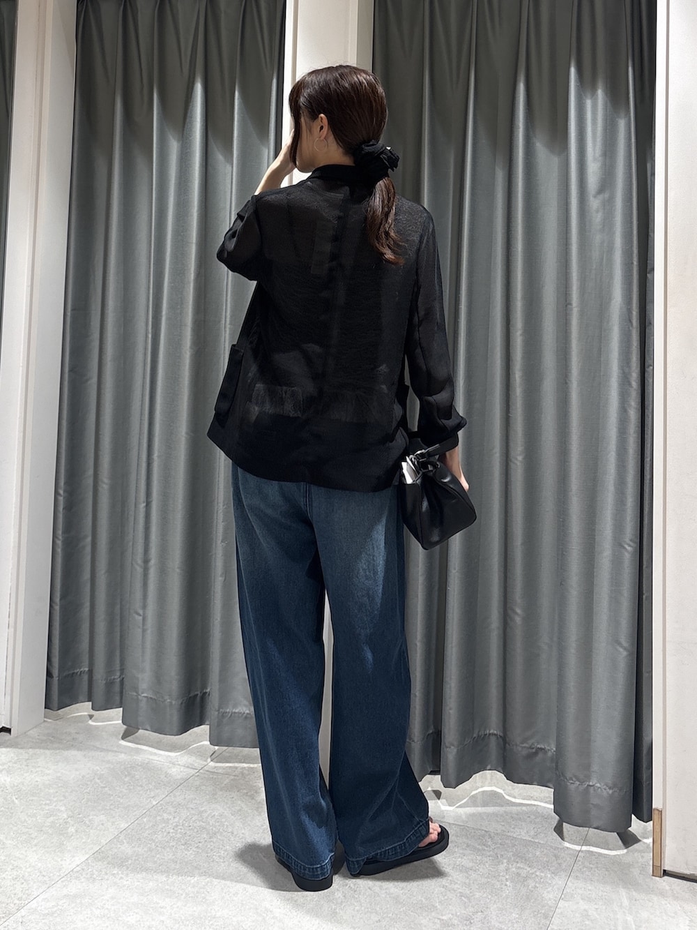 ブラック系のテーラードジャケット、ホワイト系のTシャツ/カットソー、ブルー系のデニムパンツを着用したレディースの春コーディネートの2枚目の写真