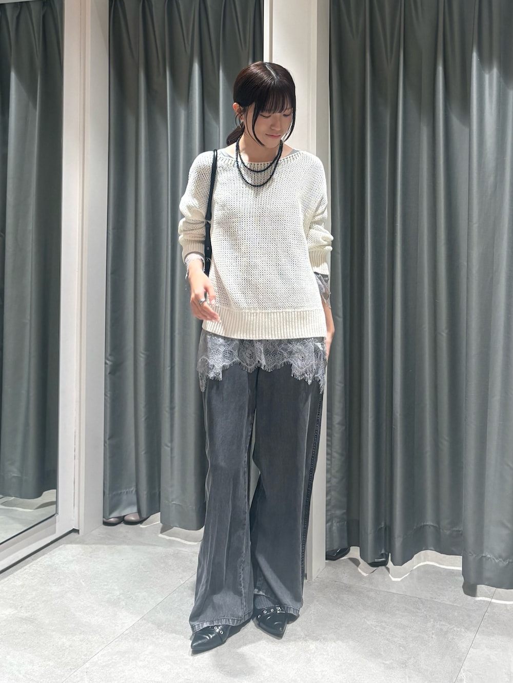 ホワイト系のニット/セーター、グレー系のTシャツ/カットソー、ブラック系のネックレスを着用したレディースの春コーディネートの2枚目の写真