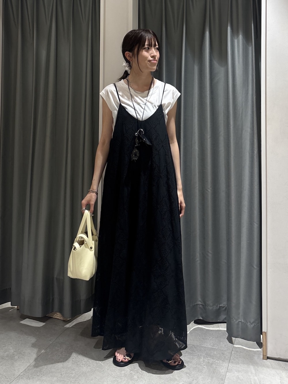 ブラック系のワンピース、ホワイト系のTシャツ/カットソーを着用したレディースの夏コーディネートの2枚目の写真