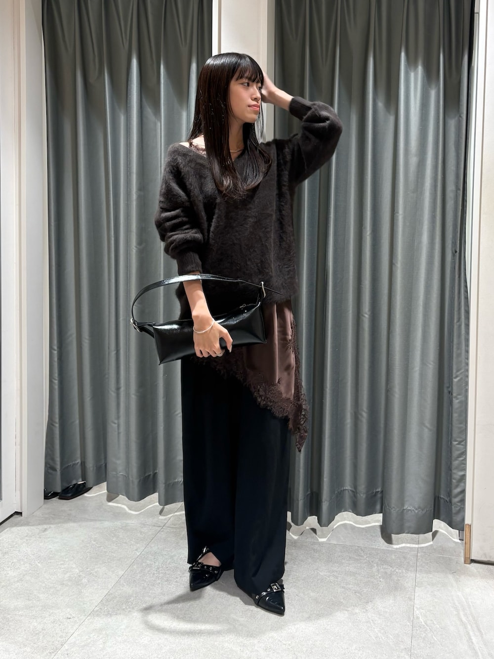 ブラウン系のニット/セーター、ブラウン系のキャミソール、ブラック系のスラックスを着用したレディースの秋コーディネートの2枚目の写真