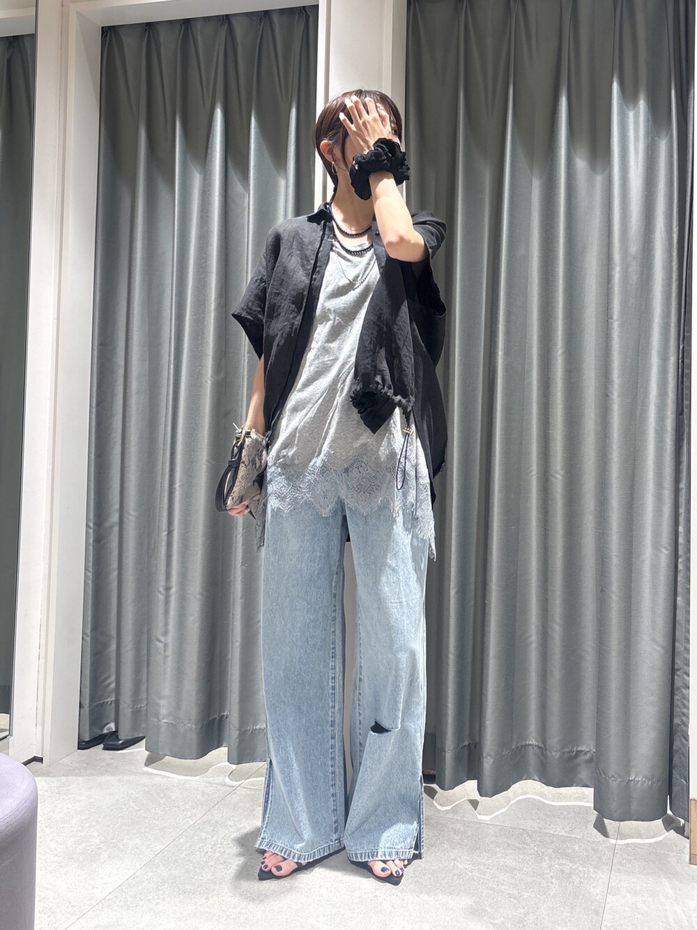 ブラック系のシャツ/ブラウス、グレー系のTシャツ/カットソー、ブルー系のデニムパンツを着用したレディースの春コーディネートの4枚目の写真