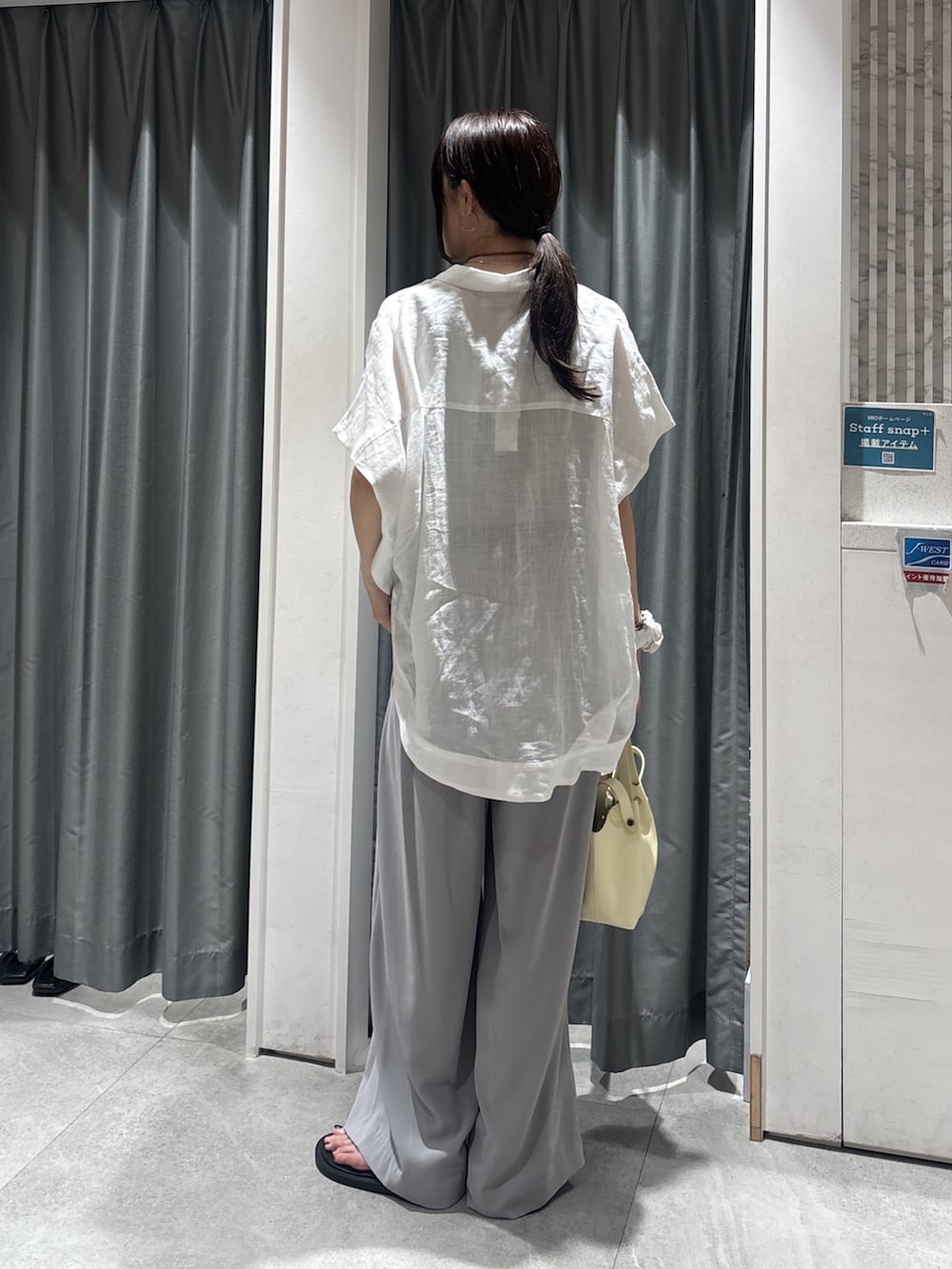 ホワイト系のシャツ/ブラウス、グレー系のニット/セーター、ベージュ系のスラックスを着用したレディースの夏コーディネートの3枚目の写真