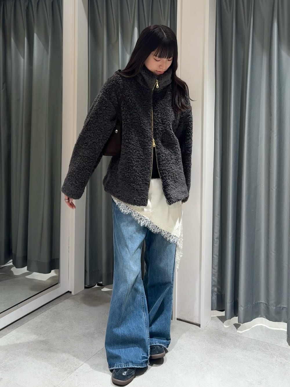 グレー系のその他アウター、ブラック系のニット/セーター、ホワイト系のキャミソールを着用したレディースの冬コーディネートの3枚目の写真