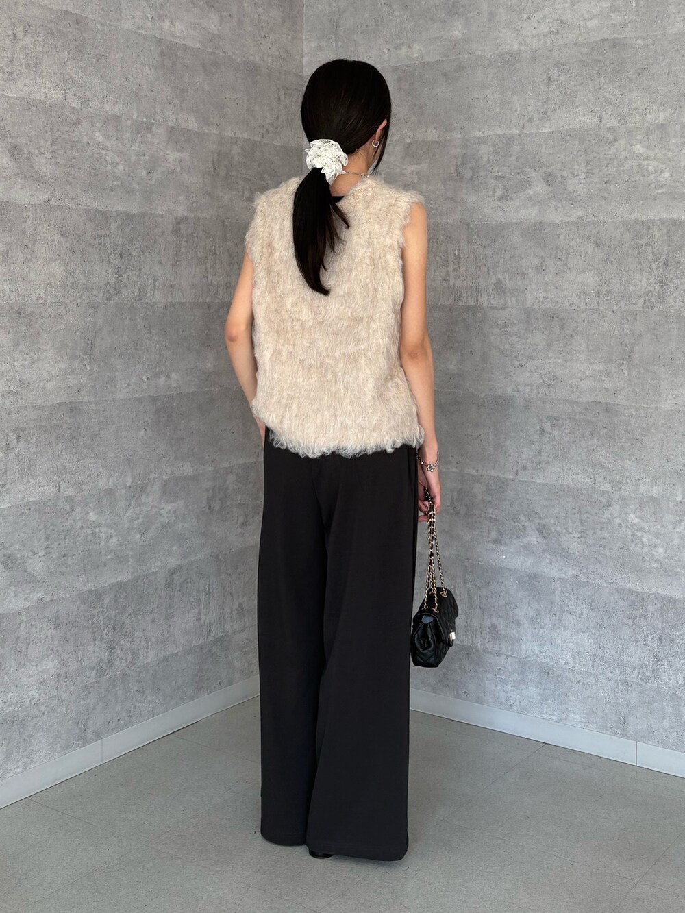 ベージュ系のニット/セーター、グレー系のその他パンツ、ブラック系のショルダーバッグを着用したレディースの夏コーディネートの3枚目の写真