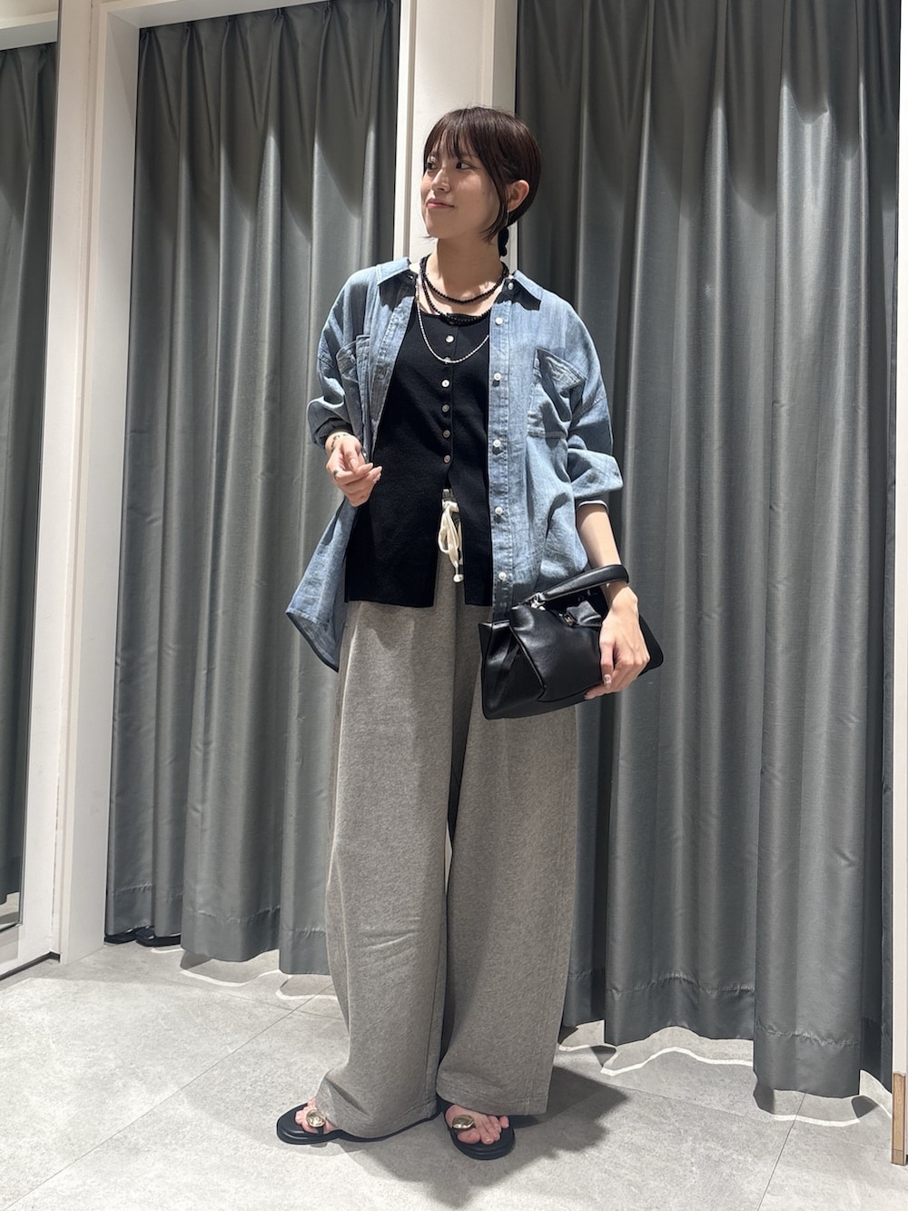 ブルー系のシャツ/ブラウス、ブラック系のニット/セーター、グレー系のその他パンツを着用したレディースの春コーディネートの3枚目の写真