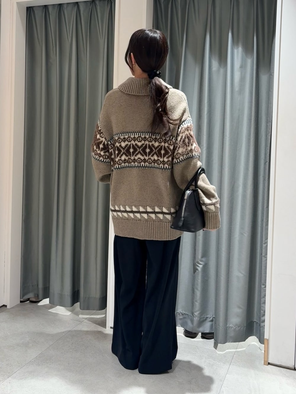 ホワイト系のTシャツ/カットソー、ベージュ系のニット/セーター、ブルー系のスラックスを着用したレディースの冬コーディネートの2枚目の写真