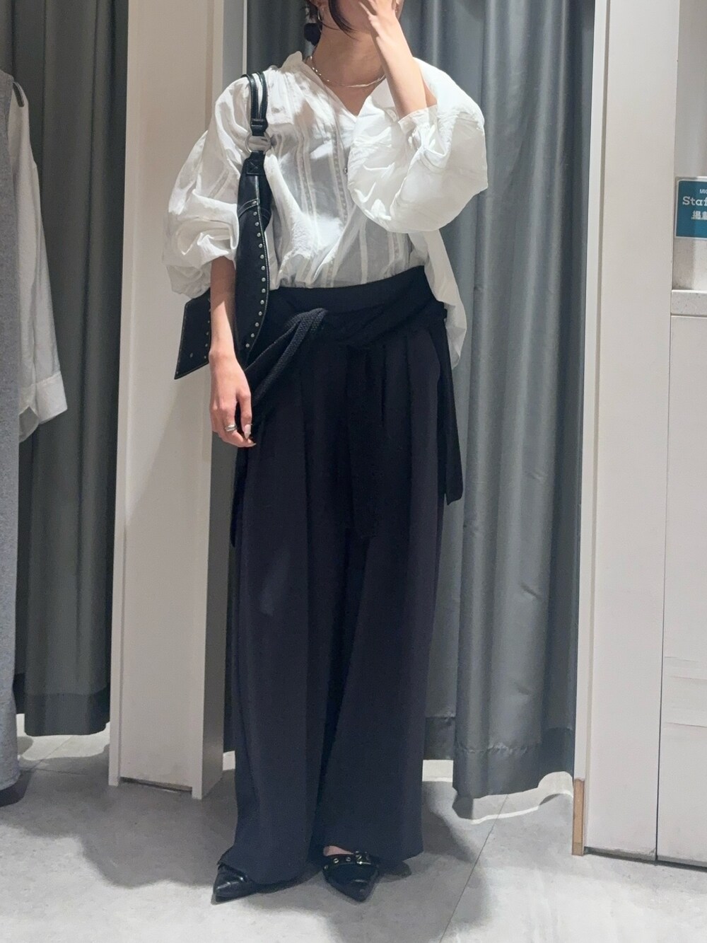 ホワイト系のシャツ/ブラウス、ブラック系のニット/セーター、グレー系のスラックスを着用したレディースの春コーディネートの2枚目の写真