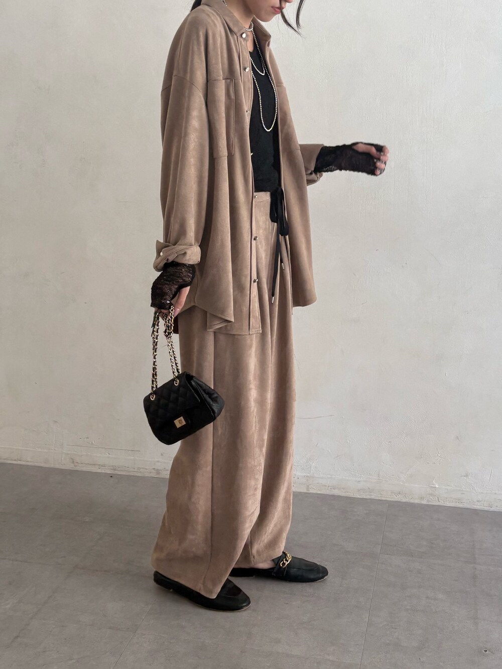 ベージュ系のシャツ/ブラウス、ベージュ系のその他パンツ、ブラック系のショルダーバッグを着用したレディースの夏コーディネートの3枚目の写真