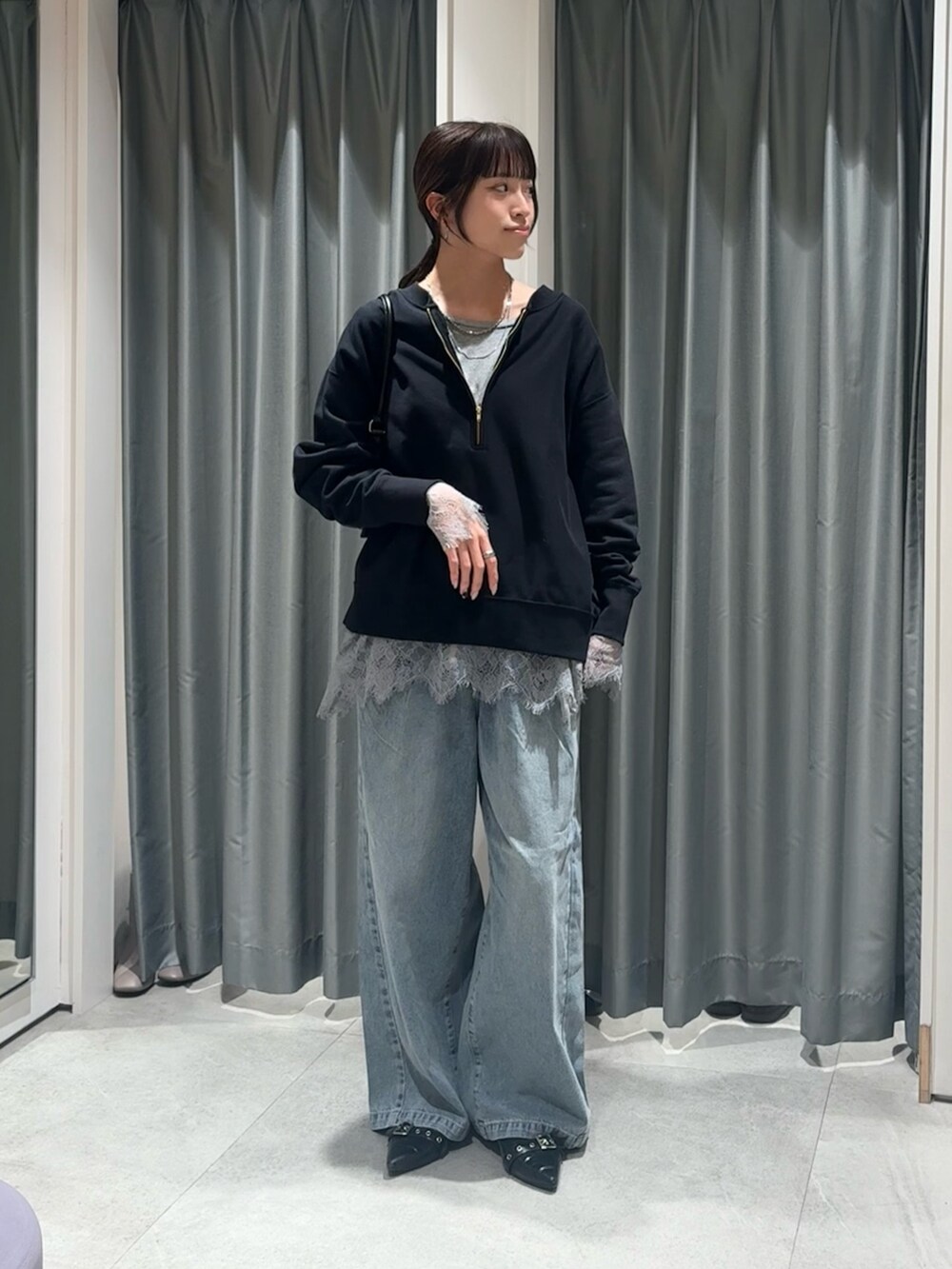 ブラック系のスウェット、グレー系のTシャツ/カットソー、ブルー系のデニムパンツを着用したレディースの冬コーディネートの3枚目の写真