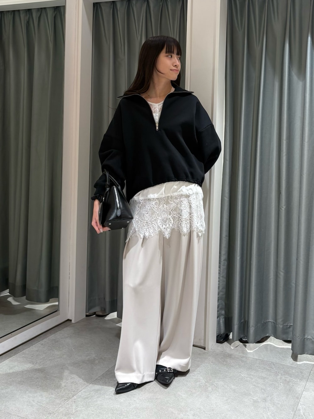 ブラック系のTシャツ/カットソー、ホワイト系のシャツ/ブラウス、グレー系のスラックスを着用したレディースの冬コーディネートの2枚目の写真