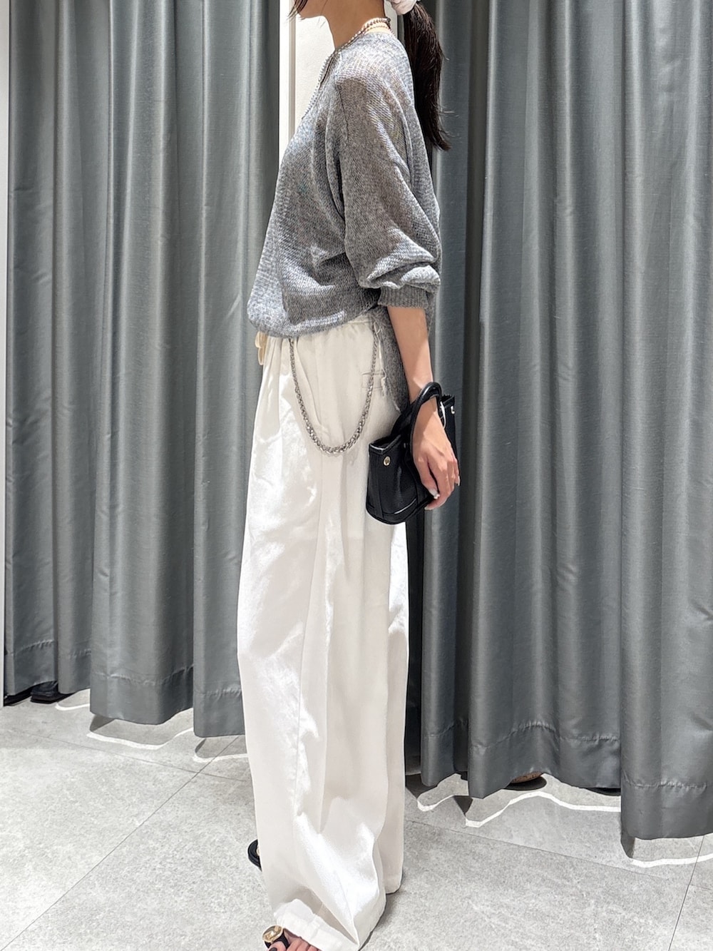 ブラック系のカーディガン/ボレロ、ホワイト系のデニムパンツ、ブラック系のサンダルを着用したレディースの夏コーディネートの3枚目の写真