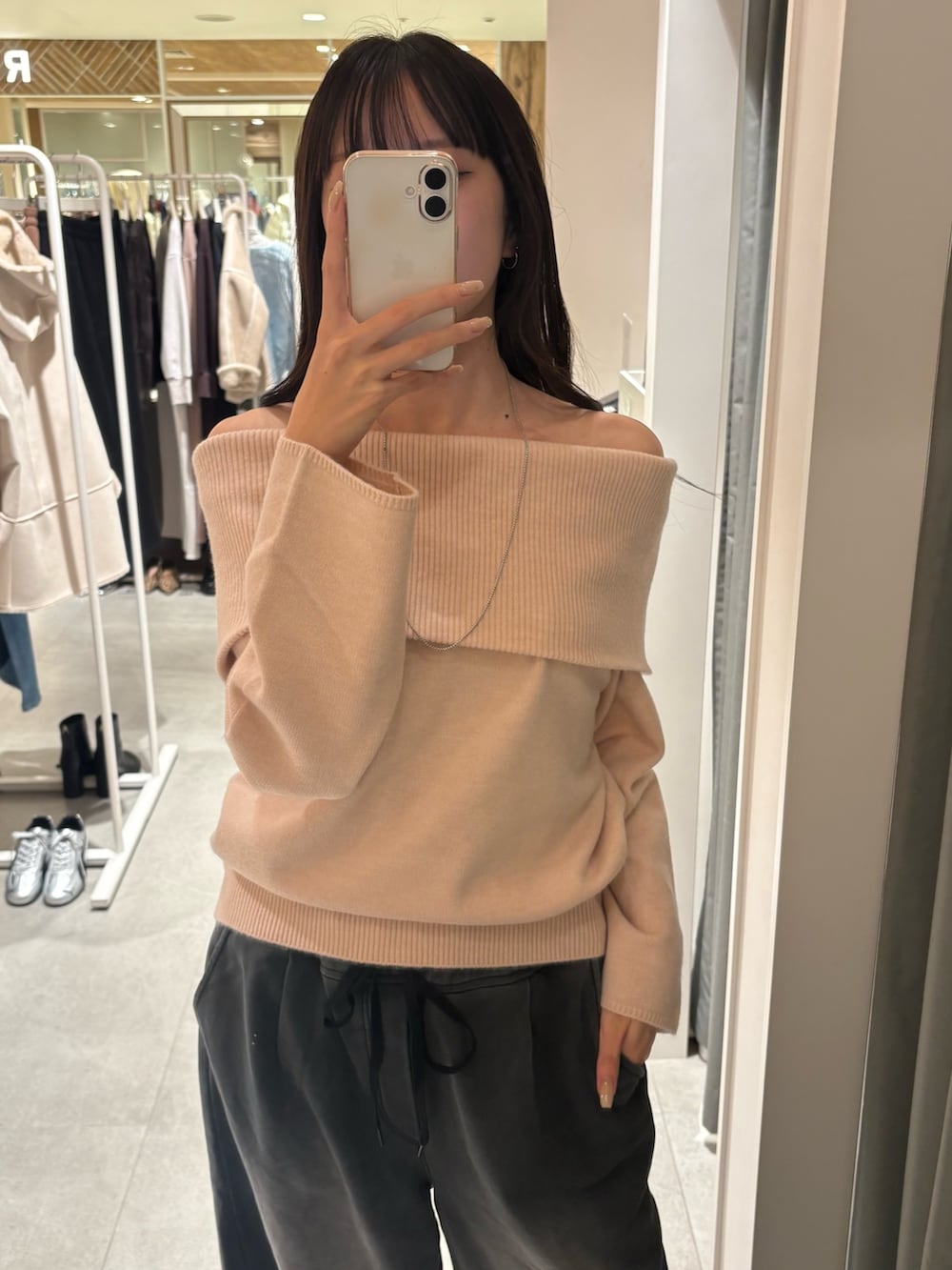 ピンク系のニット/セーター、ブラック系のその他パンツ、ホワイト系のショルダーバッグを着用したレディースの冬コーディネートの3枚目の写真