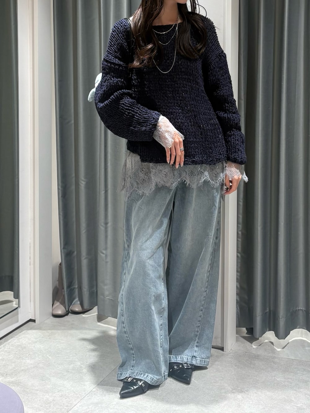 ブルー系のニット/セーター、グレー系のTシャツ/カットソー、ブルー系のデニムパンツを着用したレディースの冬コーディネートの3枚目の写真