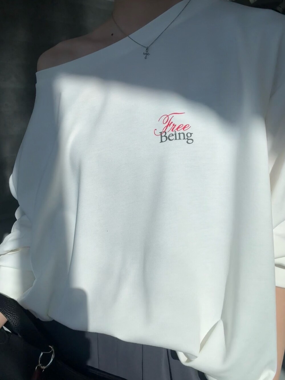 ホワイト系のTシャツ/カットソー、グレー系のその他パンツ、ブラック系のショルダーバッグを着用したレディースの冬コーディネートの4枚目の写真