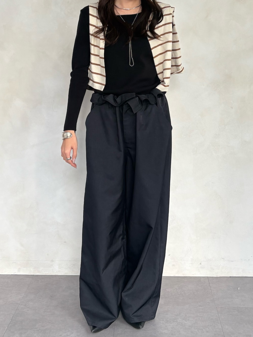 ブラック系のニット/セーター、グレー系のその他パンツを着用したレディースの冬コーディネートの2枚目の写真