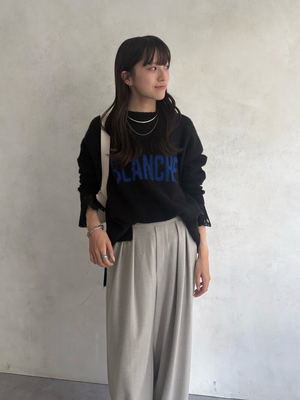 ブラック系のニット/セーター、ブラック系のシャツ/ブラウス、グレー系のその他パンツを着用したレディースの秋コーディネートの2枚目の写真